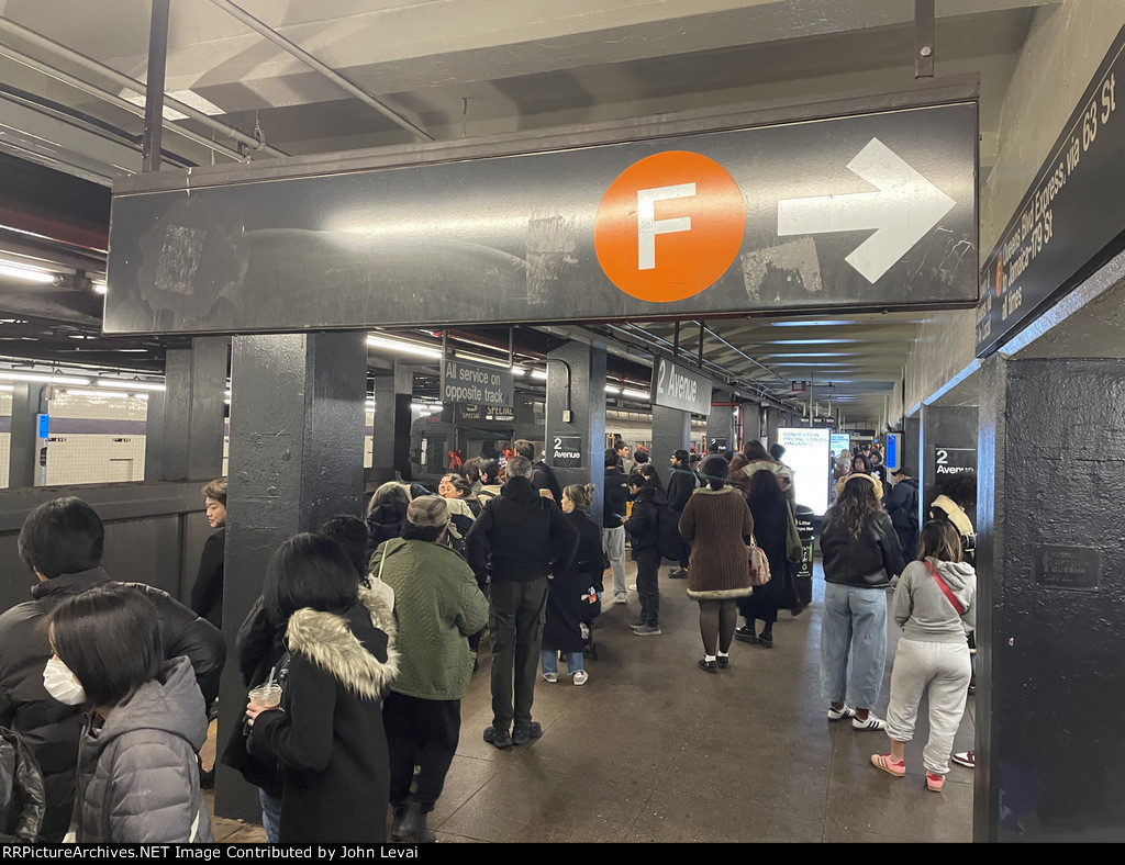 Variety of different signs here in this image at the 2nd Ave Station while the NYCTA Holiday Arnine Set rests in the background 